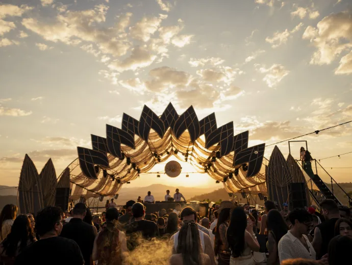 Estrutura do Piri Lounge iluminada pelo pôr do sol, com público dançando