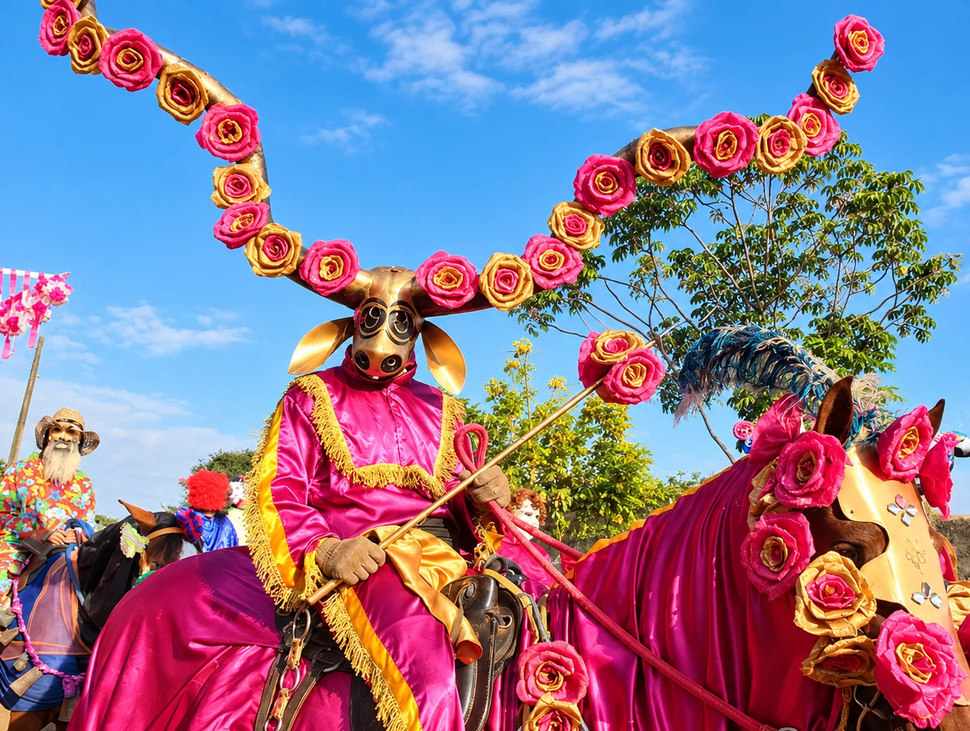 Mascarado das Cavalhadas com chapéu de flores cor-de-rosa
