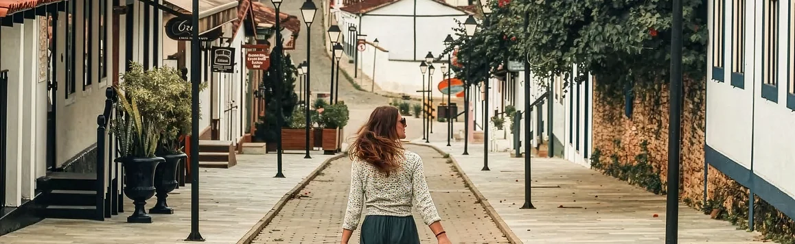 Visitante caminhando por uma rua de pedra do Centro Histórico